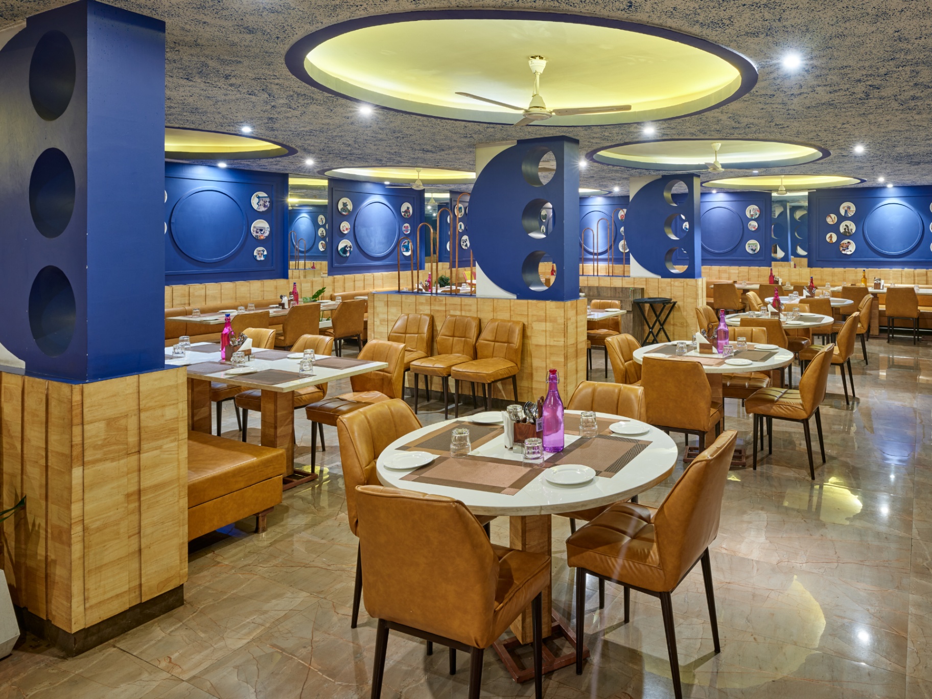 Multi-cuisine restaurant with blue accents and leather chairs