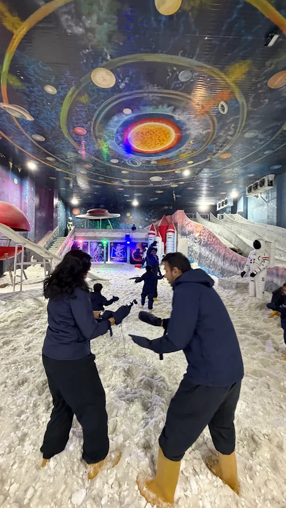 Couple playing inside the cosmic-themed snow park