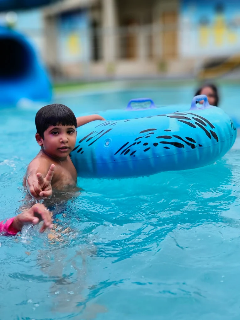 Family laughing together in the resort pool at golden hour